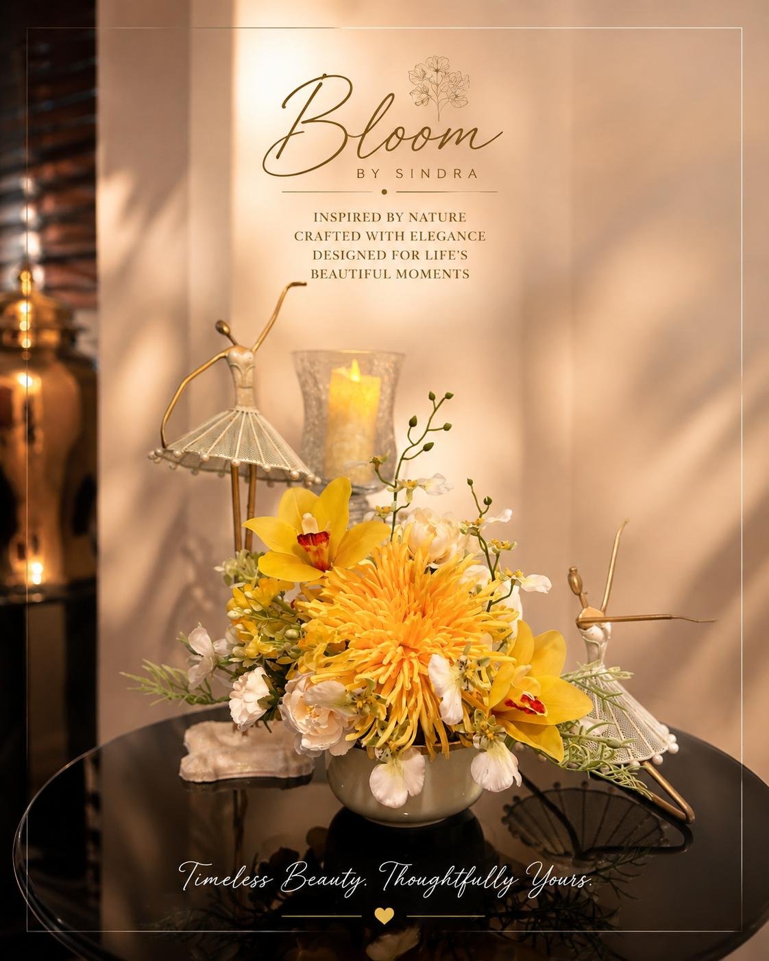Bloom by Sindra branded photo of a yellow chrysanthemum and orchid arrangement styled with ballerina figurines