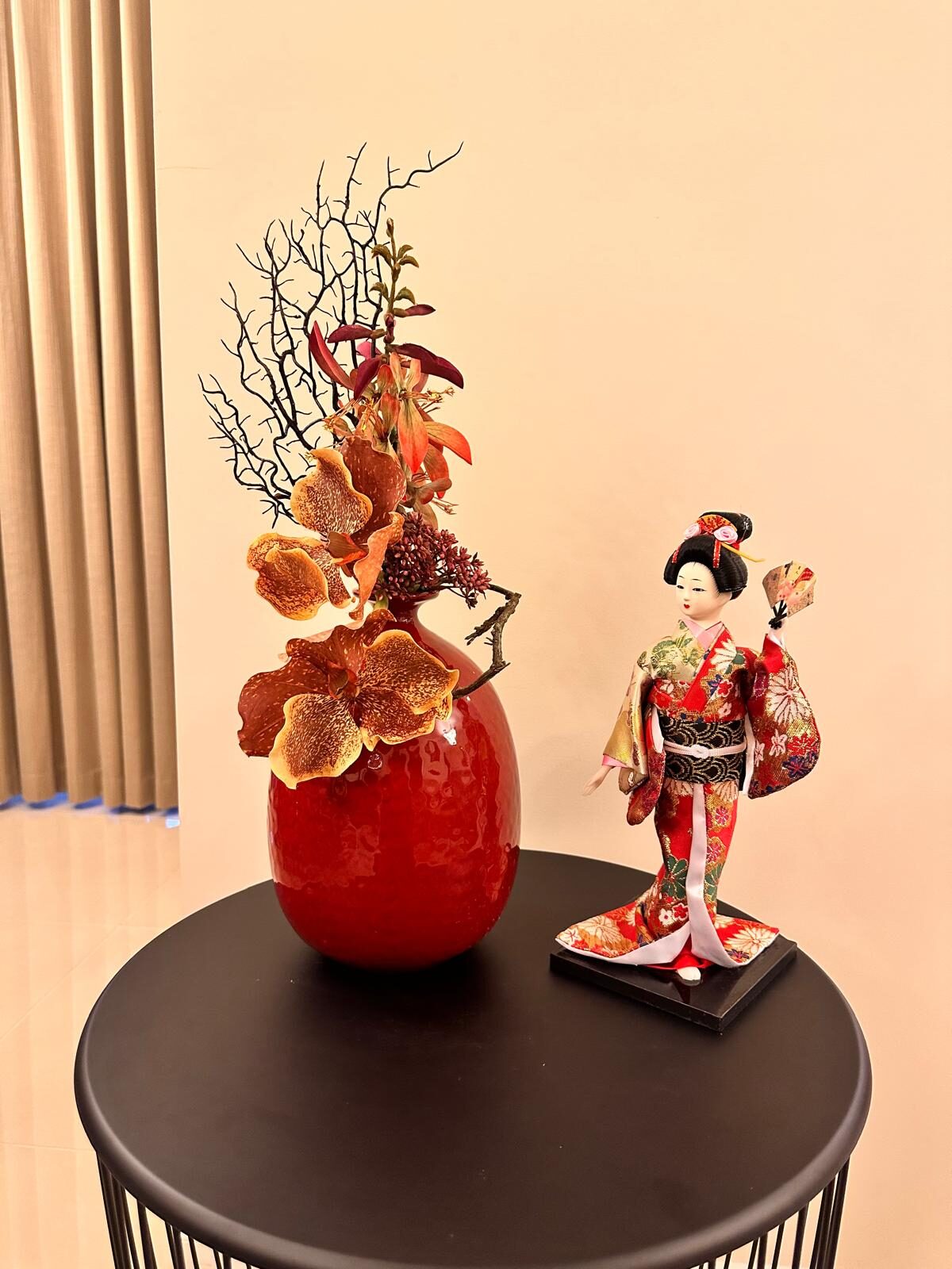 Velvet Bloom — deep burgundy orchid arrangement in a red bulb vase beside a Japanese kimono doll, by Bloom by Sindra