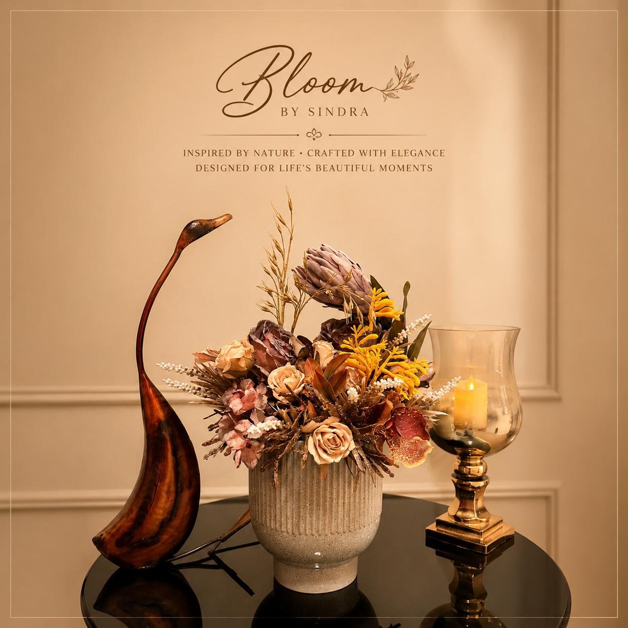 Bloom by Sindra branded photo of protea and rose arrangement in a ribbed stoneware vase beside a bronze crane and lantern